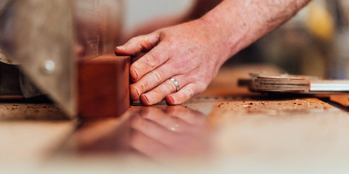 Vakman zaagt een houten balk op maat in het atelier van Ostyn in Dottenijs