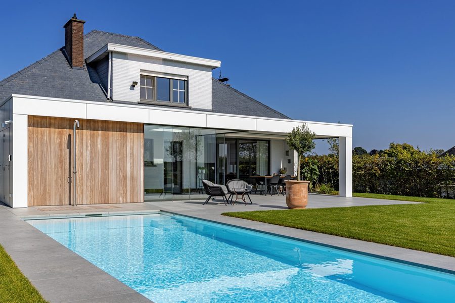 Aangebouwde poolhouse in witte Trespa met lamellendak